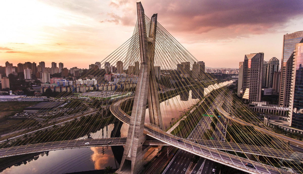 Ponte Estaiada de São Paulo ao entardecer, com arranha-céus ao fundo